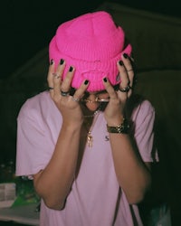 a girl wearing a pink beanie with black nails