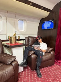 a man is sitting in a leather recliner in a private jet