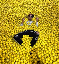 a man laying in a pile of yellow balls