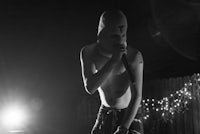 a man in a mask on stage with a microphone