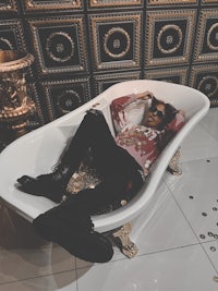 a person laying in a bathtub filled with coins